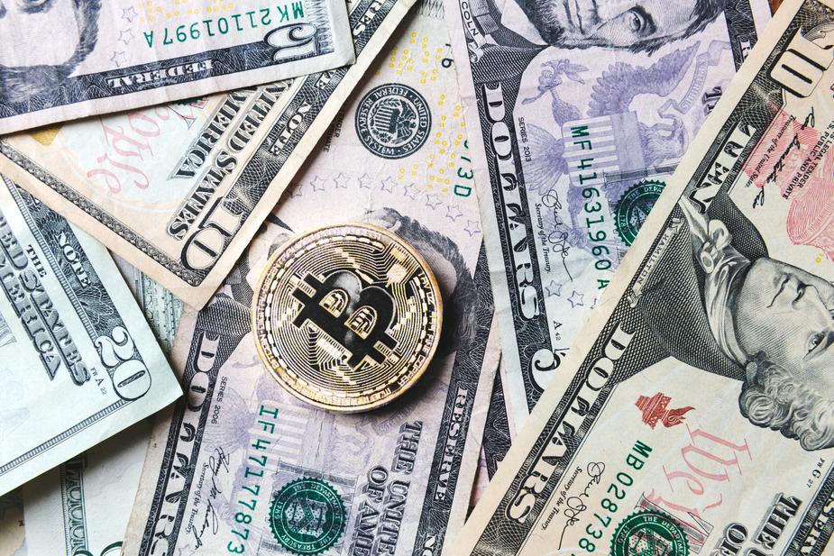 bitcoin-coin-on-bills-of-cash-money